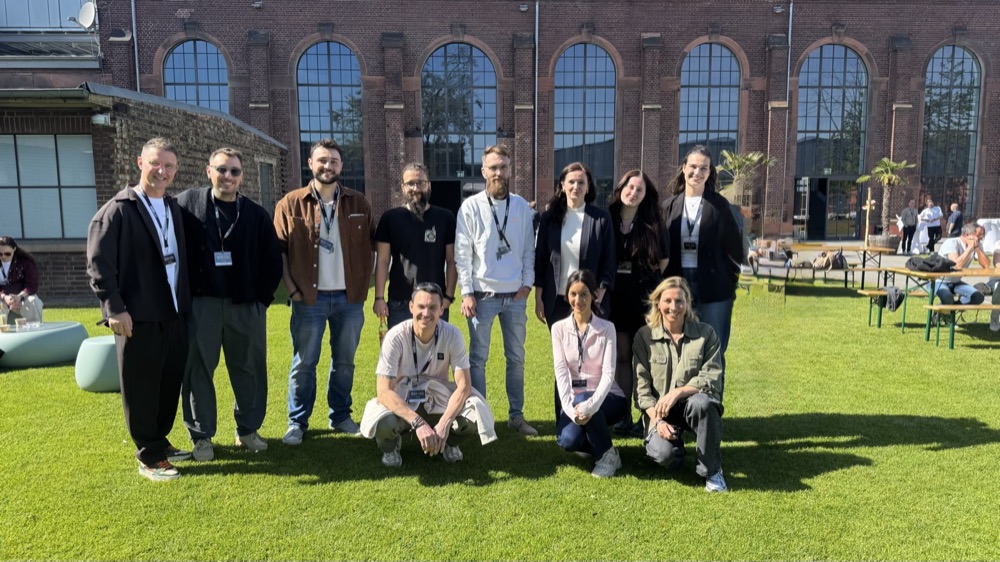 Das Team von Zahnform draußen in der Sonne, elf Menschen vor einer Backsteinfassade